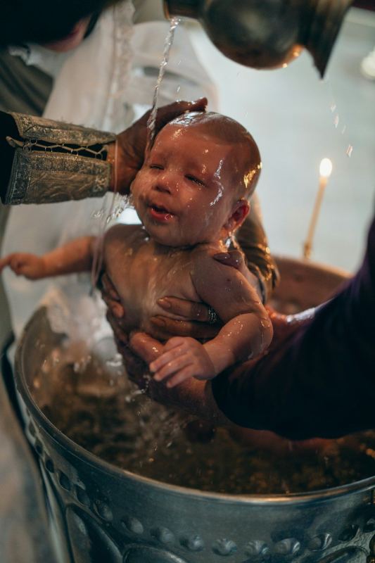 Bambino tra le braccia della madre durante il rito