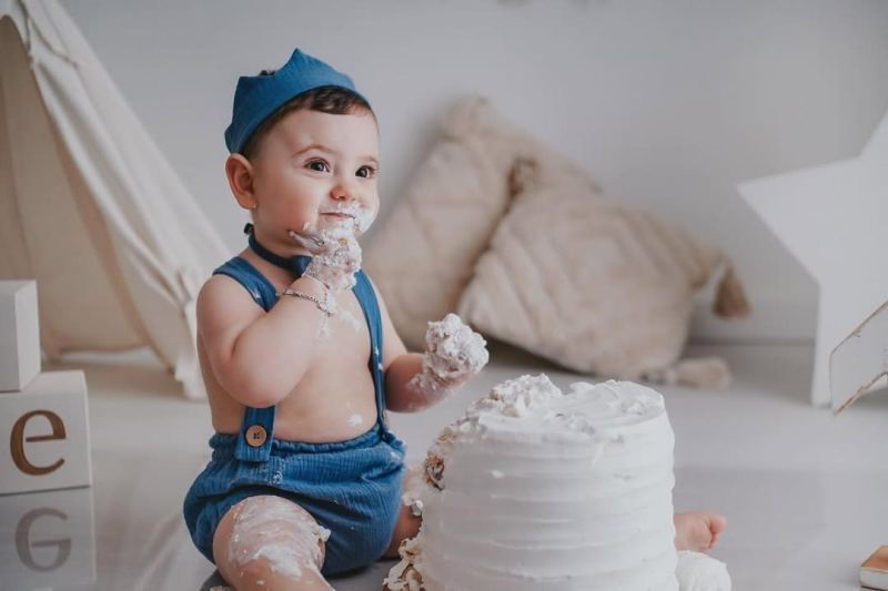 Bambino con la torta durante uno smash cake